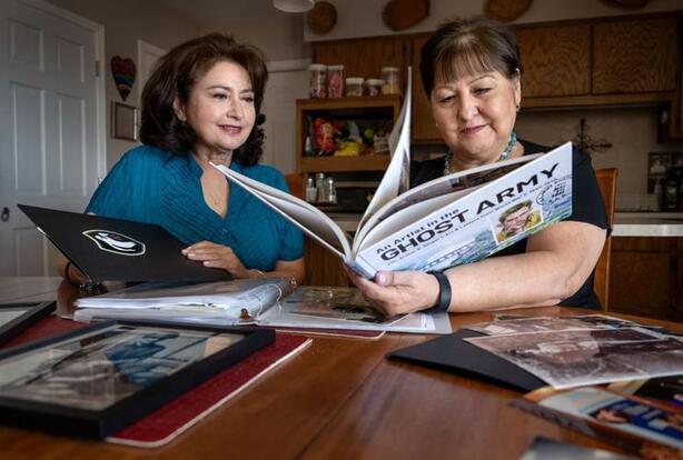 Two women look at Ghost Army book