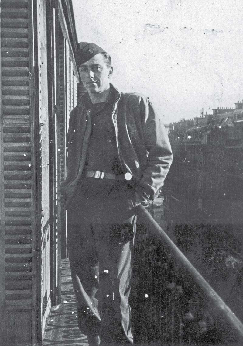 uniformed man stands at the railing of a shuttered building