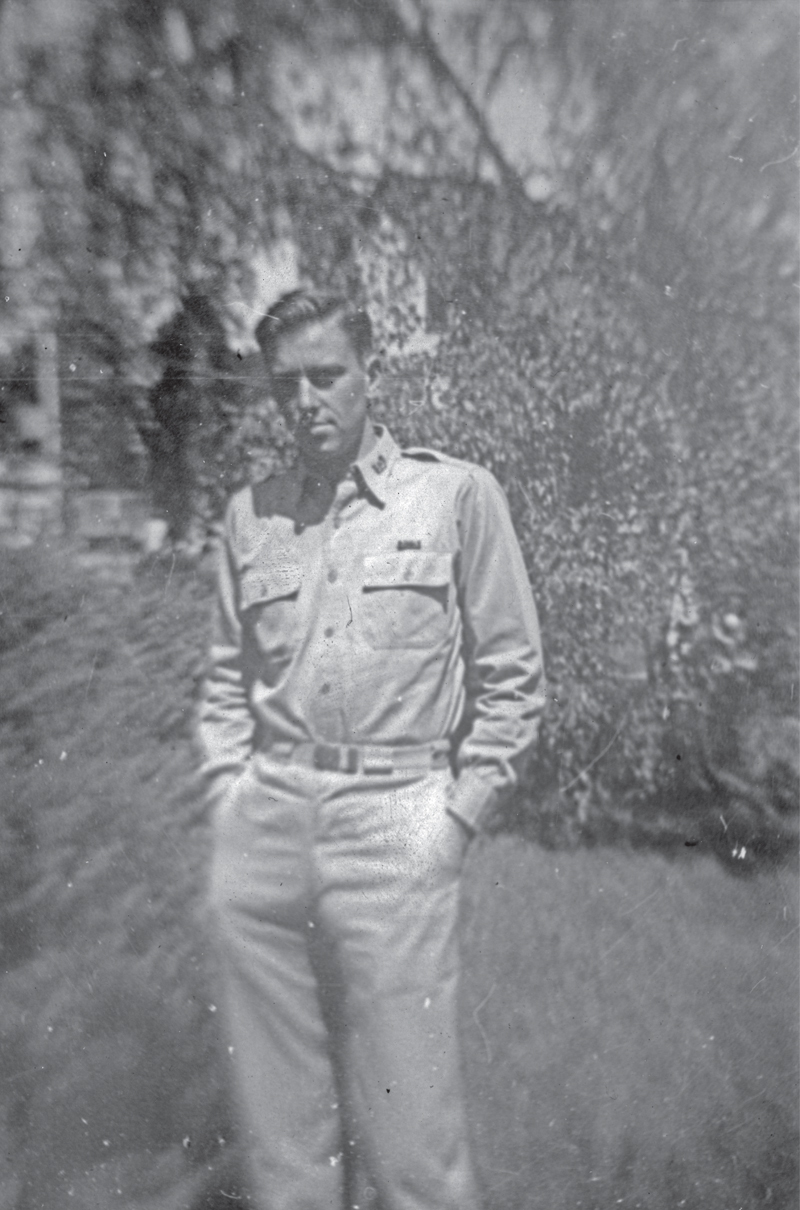 uniformed man standing in front of a tree