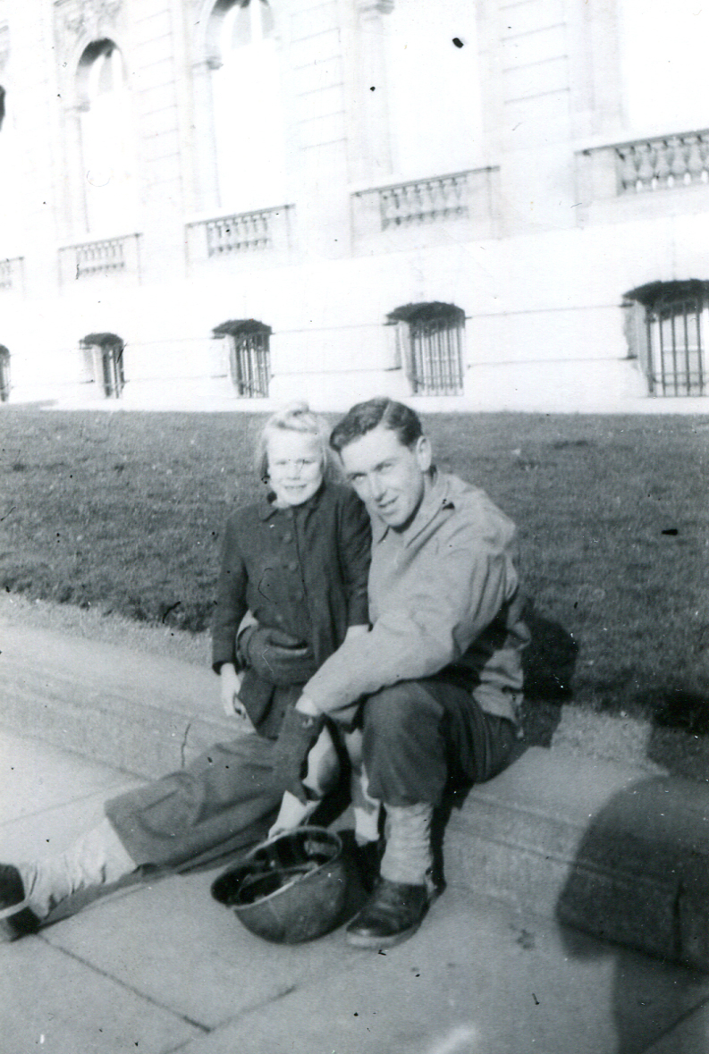 man seated on a curb with a young girl