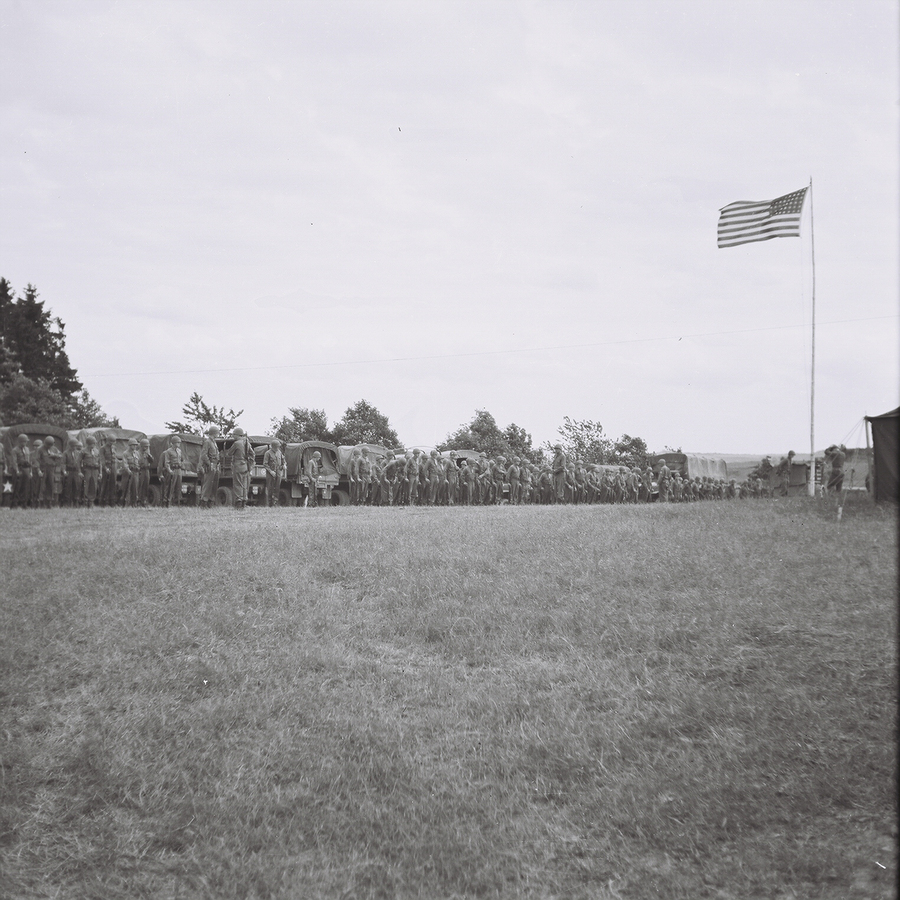 soldiers lined up at attention in front of a flag