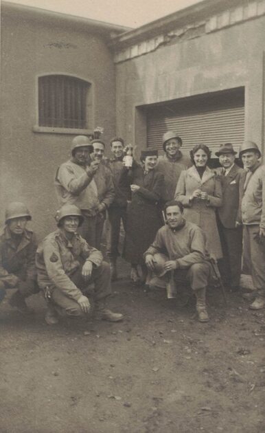 group of soldiers with three civilians outside a building