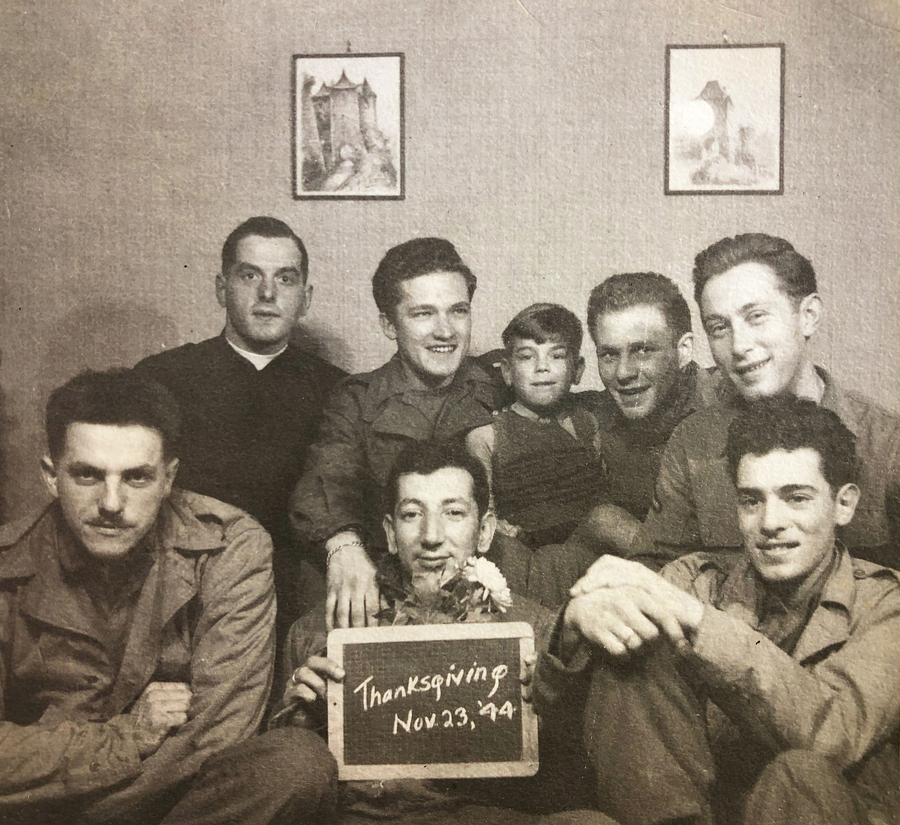 eight men in uniform holding a sign that its Thanksgiving 1944