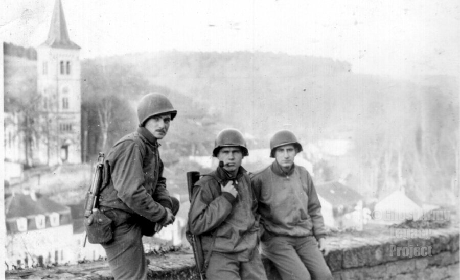 Three soldiers sit on stone wall 