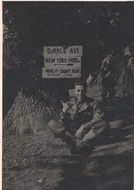 man posing in front of signs in barracks in england