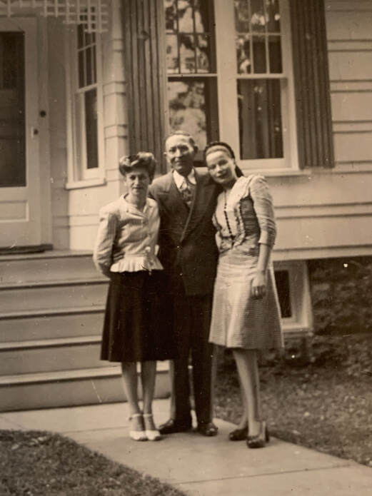 a man and two women standing in front of the steps to a house