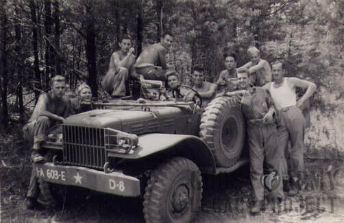 10 Soldiers posing in woods with Jeep