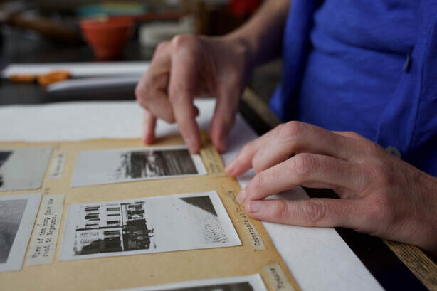 woman repairing scrapbook page during conservation