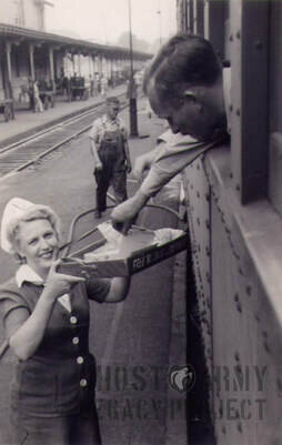 a nurse handing letters to soldier on a train