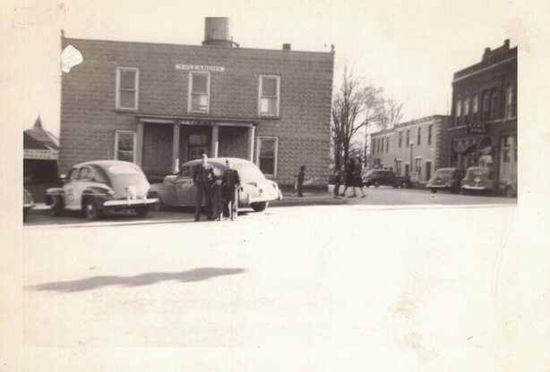 small town with home and two people posing by a car 1940s